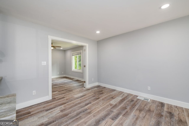 spare room with ceiling fan and wood-type flooring