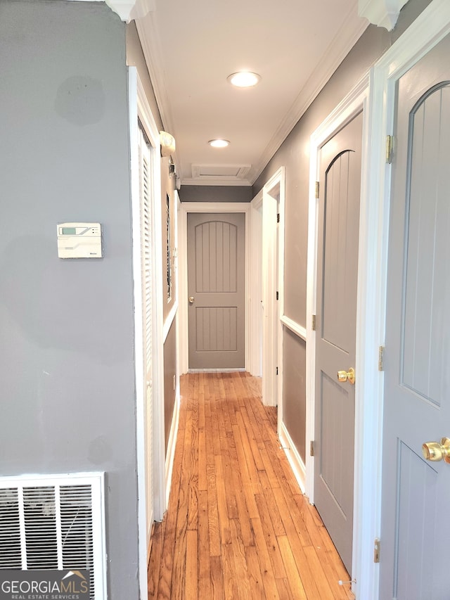 corridor featuring crown molding and light hardwood / wood-style flooring