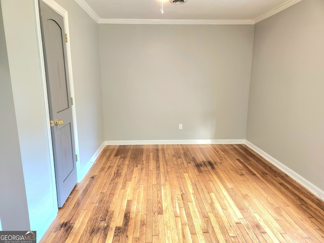 empty room featuring hardwood / wood-style flooring and crown molding