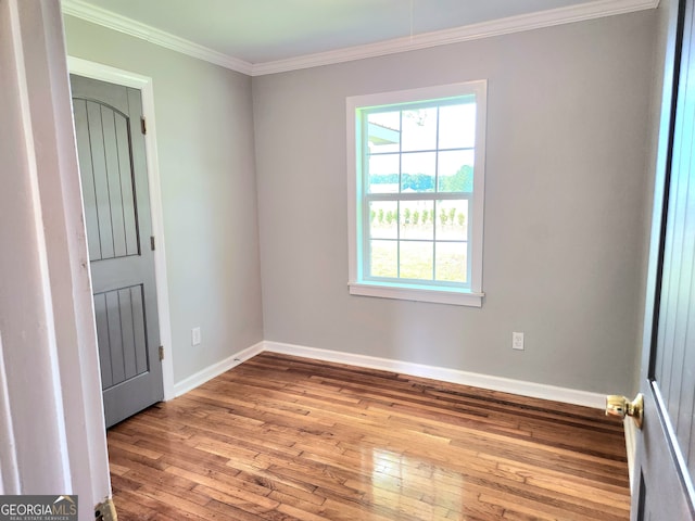 spare room with hardwood / wood-style flooring and ornamental molding