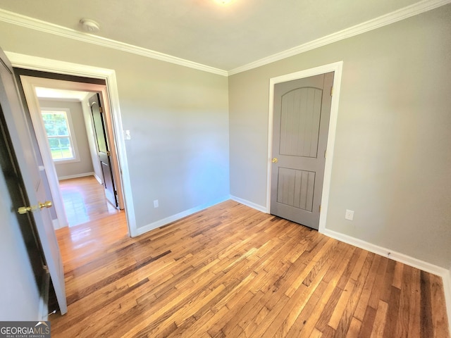 unfurnished room featuring crown molding and hardwood / wood-style floors