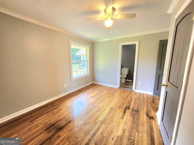 unfurnished bedroom featuring ensuite bath, light wood-type flooring, ceiling fan, and ornamental molding