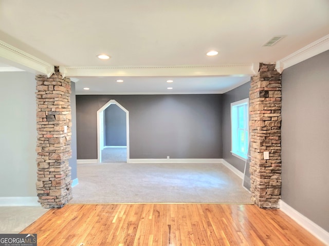 unfurnished living room with ornate columns, carpet, and crown molding