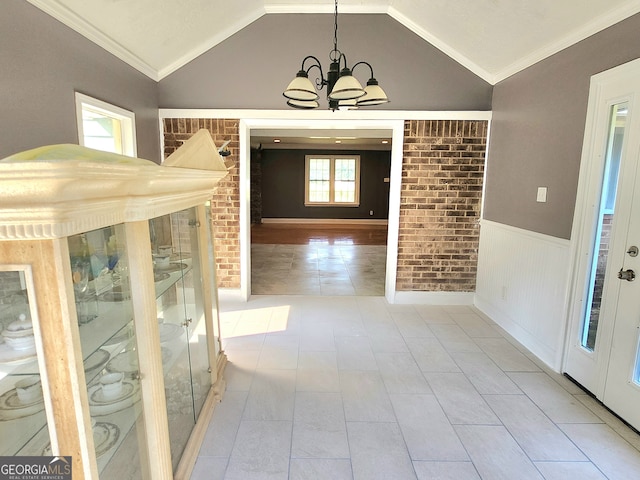 corridor featuring light tile patterned flooring, lofted ceiling, crown molding, and plenty of natural light