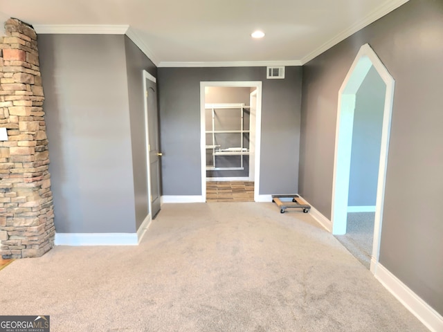 spare room with carpet floors, ornate columns, and ornamental molding