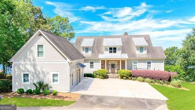 view of front of property with a front yard, driveway, and a balcony