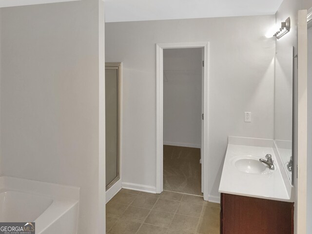 bathroom with independent shower and bath, tile patterned floors, and vanity