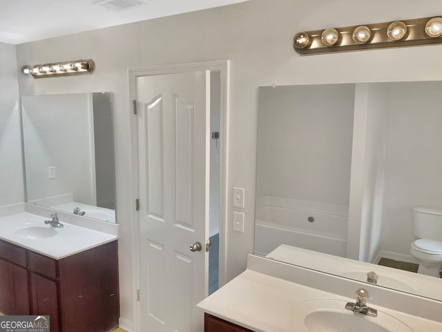 bathroom with a tub, toilet, and vanity