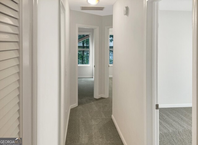 hall with dark colored carpet