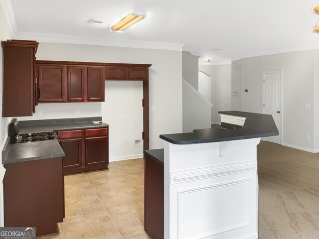 kitchen featuring a kitchen bar, stove, crown molding, a center island, and light carpet