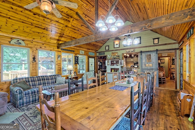 dining room with wooden walls, wood ceiling, a barn door, beamed ceiling, and wood-type flooring