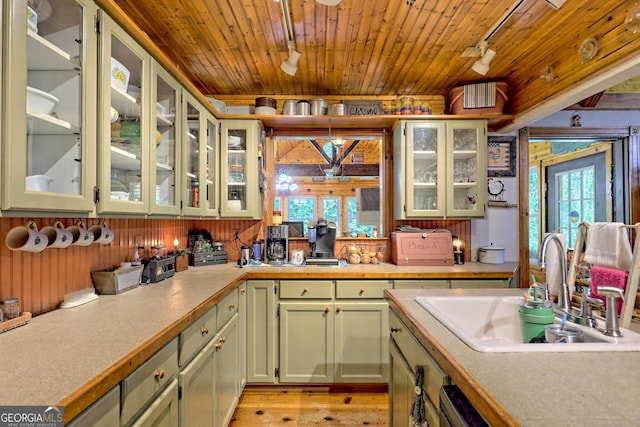 kitchen featuring sink, light hardwood / wood-style flooring, and wooden ceiling