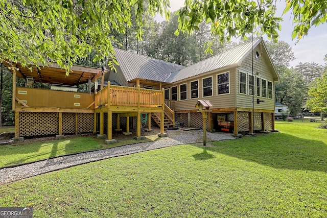 rear view of property featuring a deck and a lawn