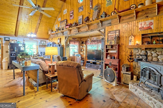 living room with wood walls, ceiling fan, light hardwood / wood-style floors, wooden ceiling, and a stone fireplace