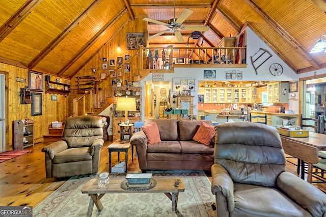 living room with hardwood / wood-style floors, wooden walls, high vaulted ceiling, and wooden ceiling