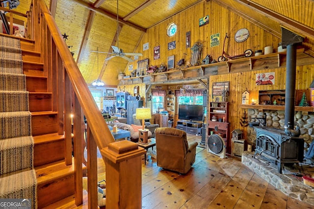 living room with a wood stove, a healthy amount of sunlight, wooden walls, and wood ceiling