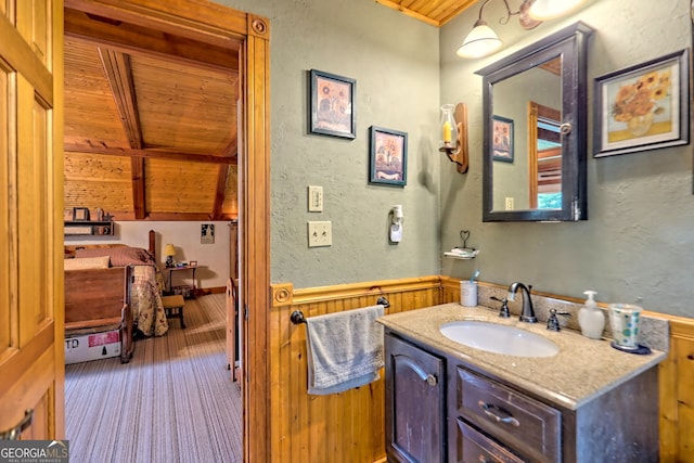 bathroom with vanity, wooden ceiling, lofted ceiling, and wooden walls