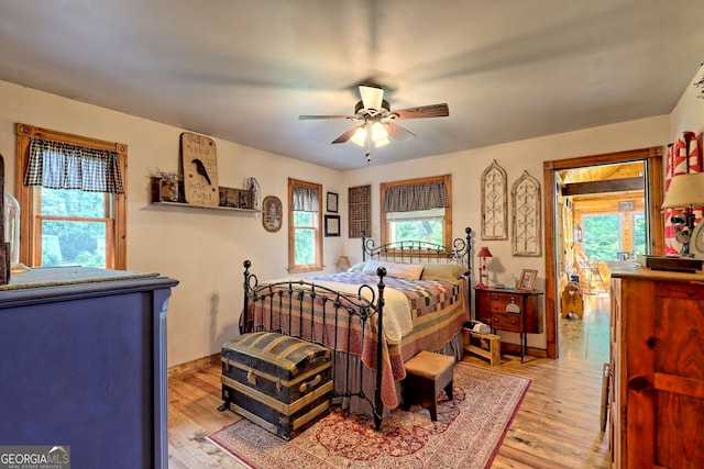 bedroom with multiple windows, ceiling fan, and light wood-type flooring