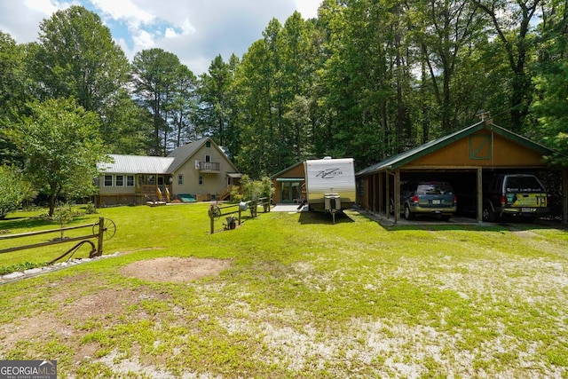 view of yard with a garage, an outbuilding, and a carport