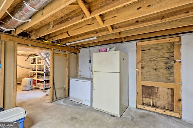 basement featuring white fridge and refrigerator