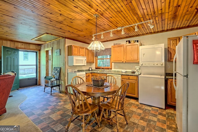 kitchen featuring stacked washer / dryer, rail lighting, white appliances, wood ceiling, and decorative light fixtures