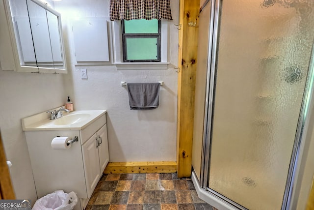 bathroom featuring a shower with shower door, vanity, and tile patterned floors