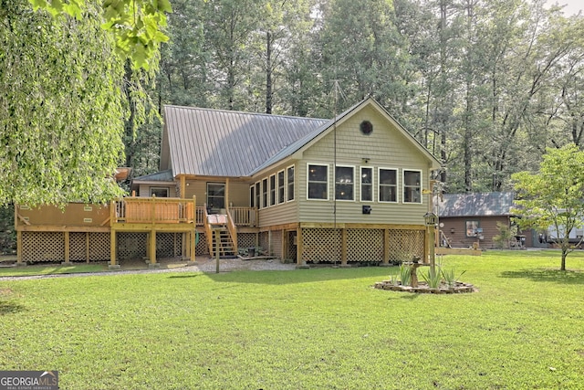 rear view of house featuring a lawn and a wooden deck