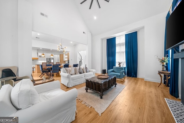 living room with light hardwood / wood-style flooring and high vaulted ceiling