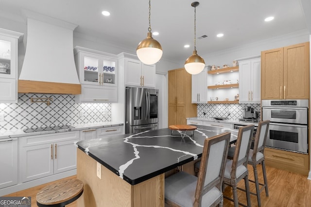 kitchen featuring a kitchen island, tasteful backsplash, stainless steel appliances, and white cabinets