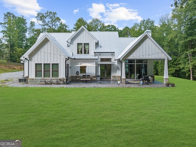 rear view of house with a patio, central AC, and a lawn