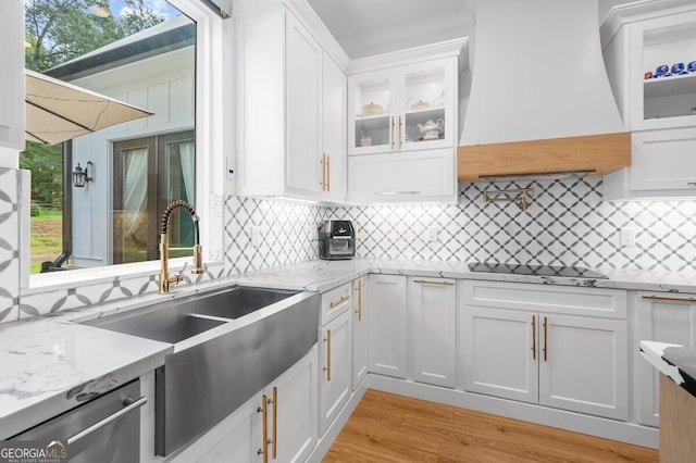 kitchen featuring light hardwood / wood-style floors, white cabinetry, a wealth of natural light, and tasteful backsplash