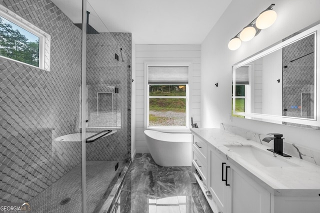 bathroom with a healthy amount of sunlight, tile patterned floors, plus walk in shower, and vanity