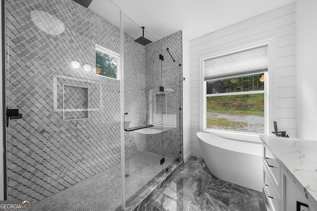 bathroom featuring independent shower and bath, vanity, and plenty of natural light