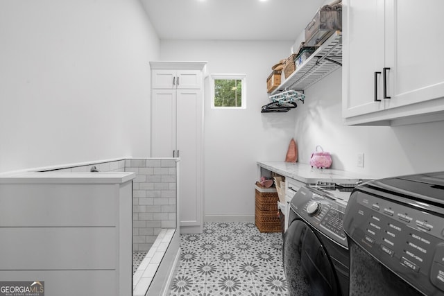 interior space featuring cabinets, washer and dryer, and light tile patterned floors