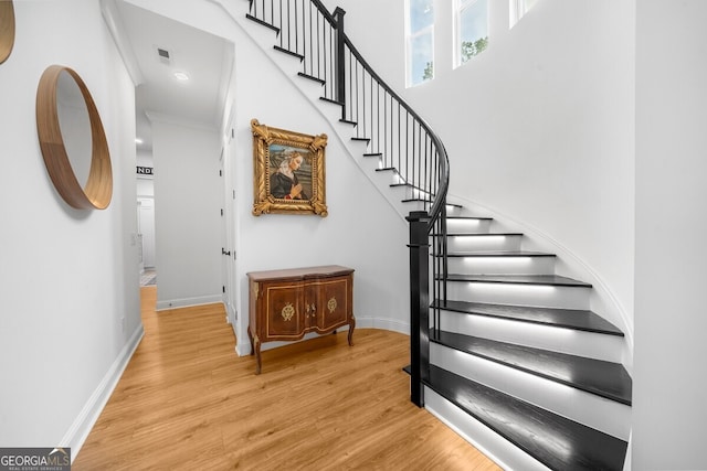 stairway featuring ornamental molding and hardwood / wood-style flooring