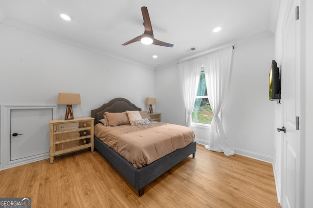 bedroom featuring light hardwood / wood-style floors, ornamental molding, and ceiling fan