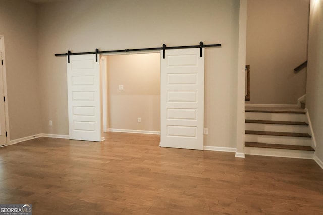 interior space with a barn door and hardwood / wood-style floors