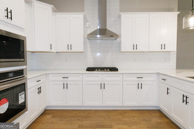 kitchen with sink, white cabinets, decorative light fixtures, and appliances with stainless steel finishes