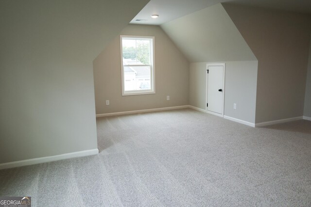 additional living space with light carpet and lofted ceiling