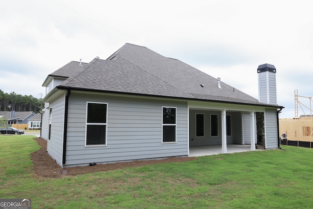 back of property with a patio area and a yard