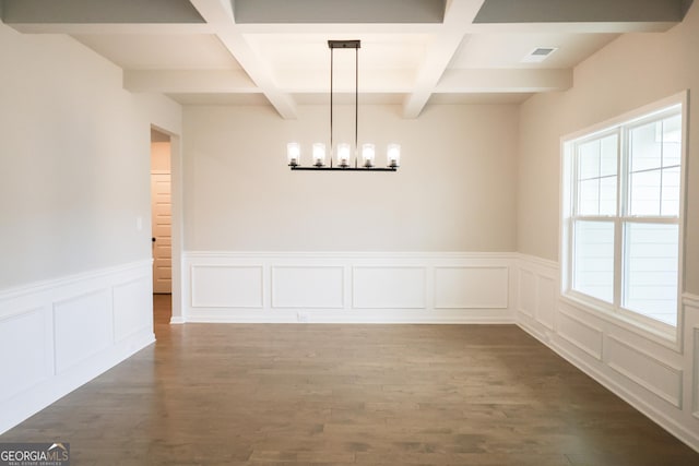 unfurnished dining area featuring coffered ceiling, beam ceiling, dark wood-type flooring, and an inviting chandelier