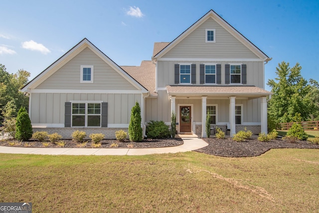 view of front of property with a porch, brick siding, board and batten siding, and a front lawn