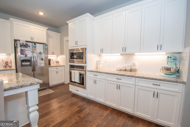 kitchen featuring dark wood finished floors, decorative backsplash, white cabinets, and stainless steel appliances