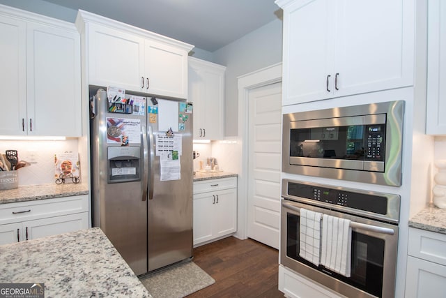 kitchen featuring dark hardwood / wood-style floors, light stone counters, white cabinetry, and appliances with stainless steel finishes