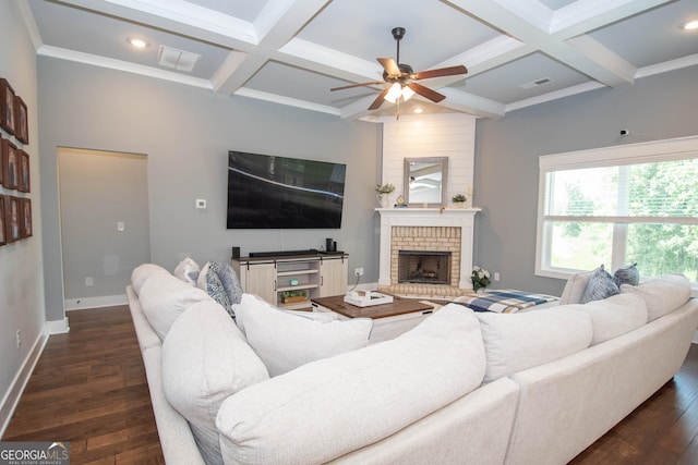 living room featuring dark hardwood / wood-style flooring, coffered ceiling, ceiling fan, beamed ceiling, and a fireplace