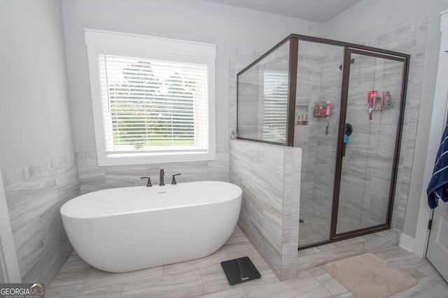 bathroom with independent shower and bath and tile walls