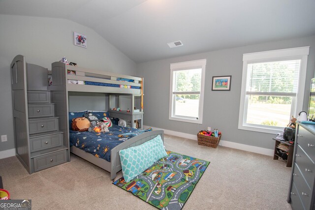 bedroom with light colored carpet, lofted ceiling, and multiple windows