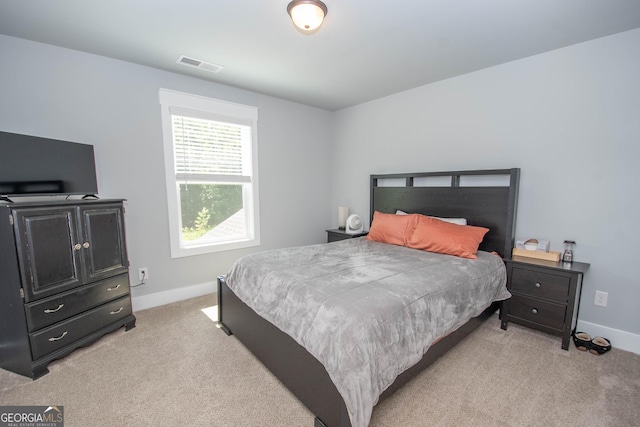 bedroom featuring baseboards, visible vents, and light carpet