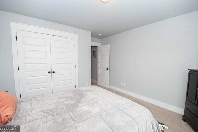 carpeted bedroom with baseboards and a closet