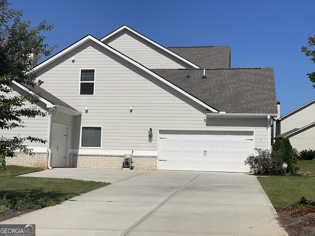 view of front of home with a garage, brick siding, concrete driveway, and a shingled roof